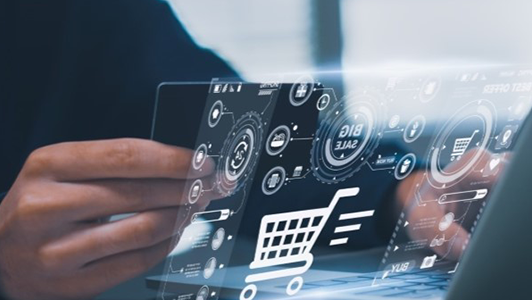 A person holds a credit card near a laptop, with a transparent digital interface overlay showing a shopping cart icon, sales data, and technology-themed graphics, representing online shopping and digital transactions.