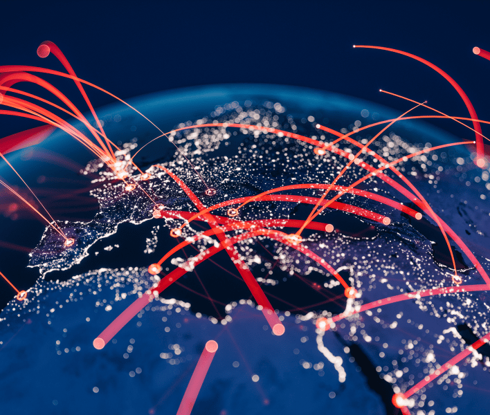 A view of Europe, parts of Asia, and Africa from space at night, with city lights illuminated. Bright red lines arc across the continents, symbolising global digital or data connections and international network activity.