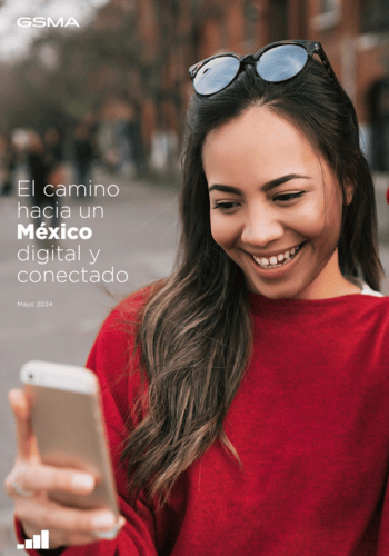 A woman in a red sweater smiles while looking at her smartphone. She is outdoors on a city street with blurred buildings in the background. The text reads, "El camino hacia un México digital y conectado," and "Mayo 2024" with the GSMA logo.
