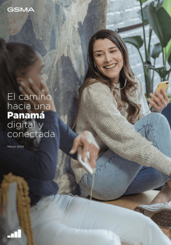 Two women sit together, one holding a phone and smiling, the other using a laptop. They're in a casual setting with plants and a wall behind them. Text on the image reads: "GSMA: El camino hacia una Panamá digital y conectada. Marzo 2024.