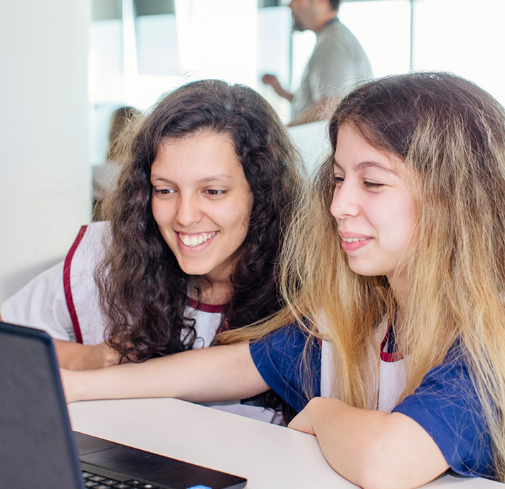 Two girls look at laptop