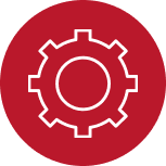 A white gear icon with eight cogs is centered inside a solid red circle. The gear has a hollow center, and the overall design is simple and outlined, resembling a settings or configuration symbol. The background outside the circle is light gray.