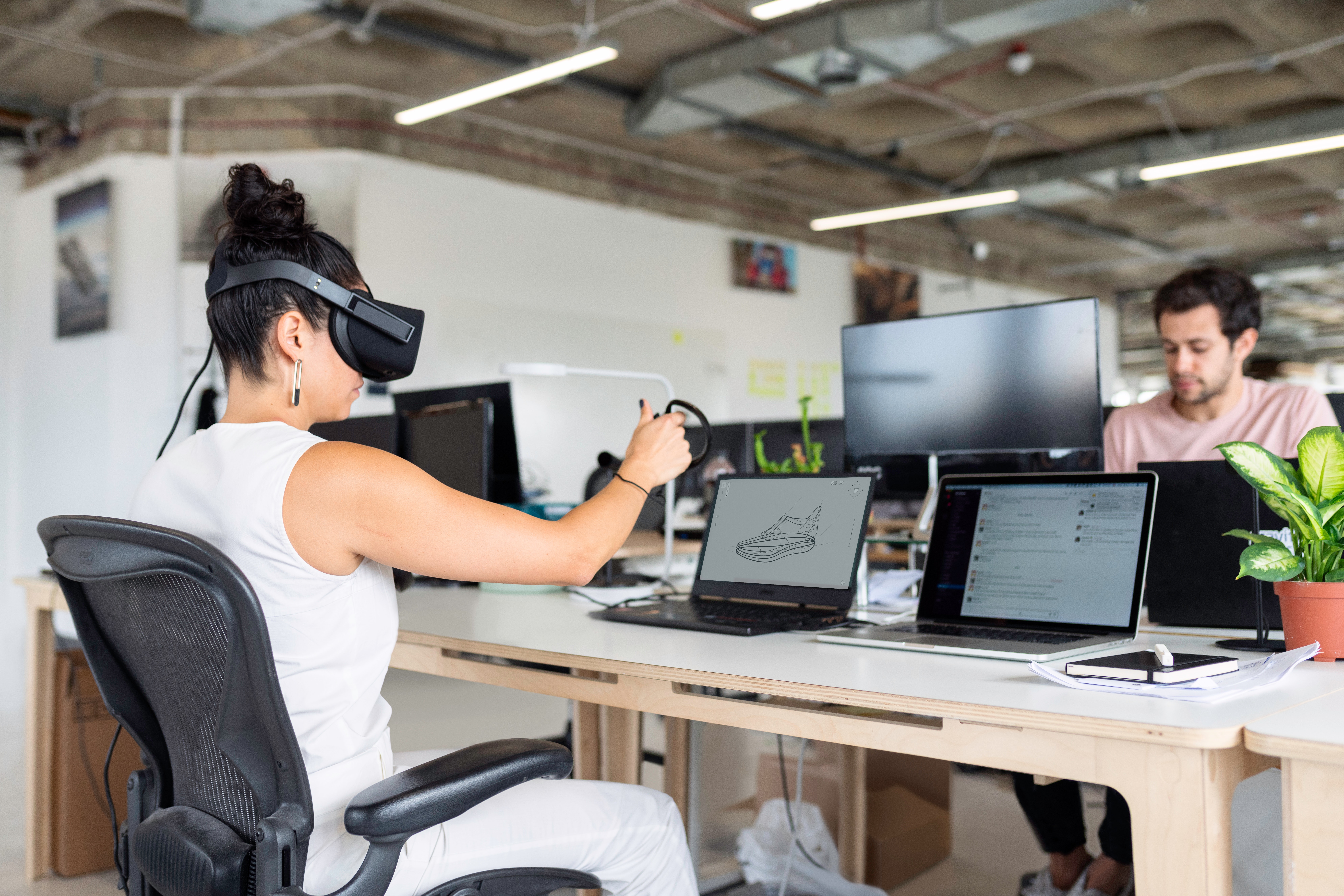 woman-in-white-tank-top-using-black-laptop-computer-with-vr-headset