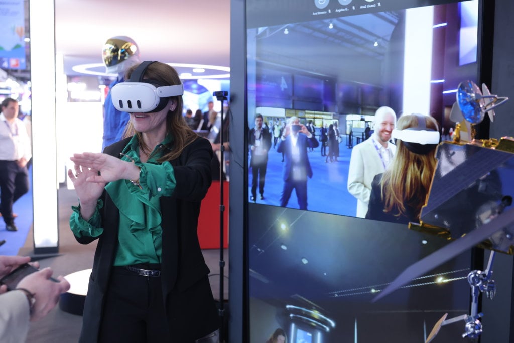 Woman experiencing virtual reality with a vr headset in a tech exhibition booth.