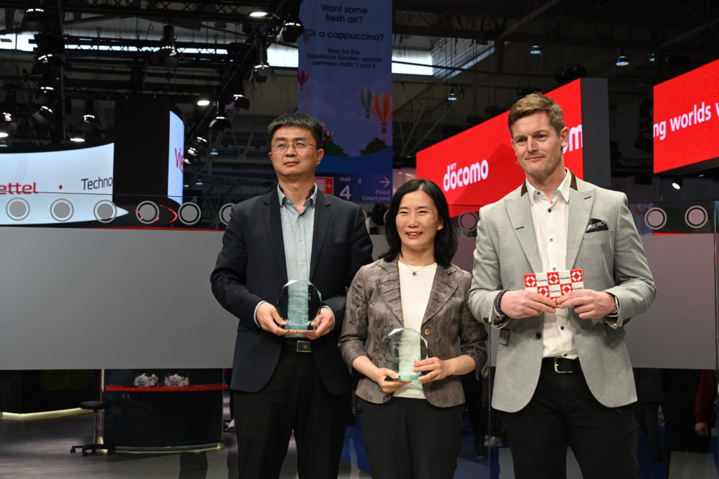 Three professionals holding awards at a technology event.