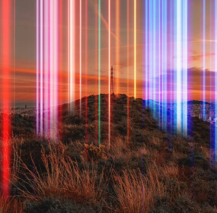 A vivid sunset landscape with a hill covered in dry bushes. An electricity pylon stands atop the hill. Vertical, multicolored light streaks in shades of red, pink, blue, and white overlay the scene, creating a surreal effect. The sky is orange with wispy clouds.