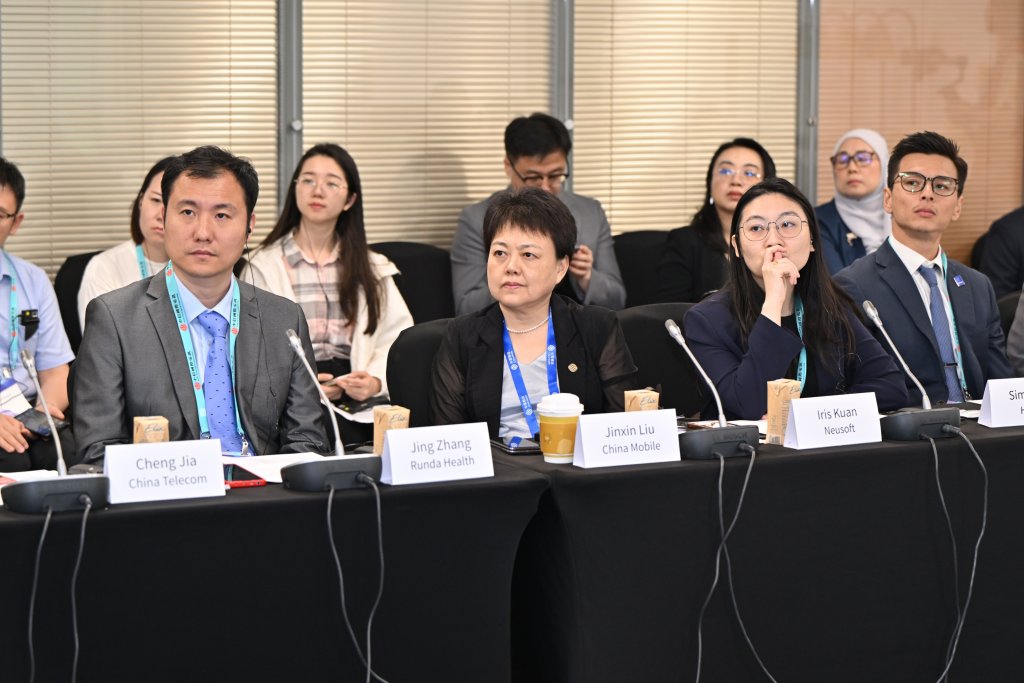 Connected healthcare Roundtable at MWC Shanghai 2026 attendees sit at tables, focused and listening. Cheng Jia, Jing Zhang, Jinmin Liu, and Iris Kuan. Behind them, more participants watch attentively.