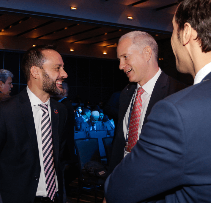 A group of people in suits talking to each other.