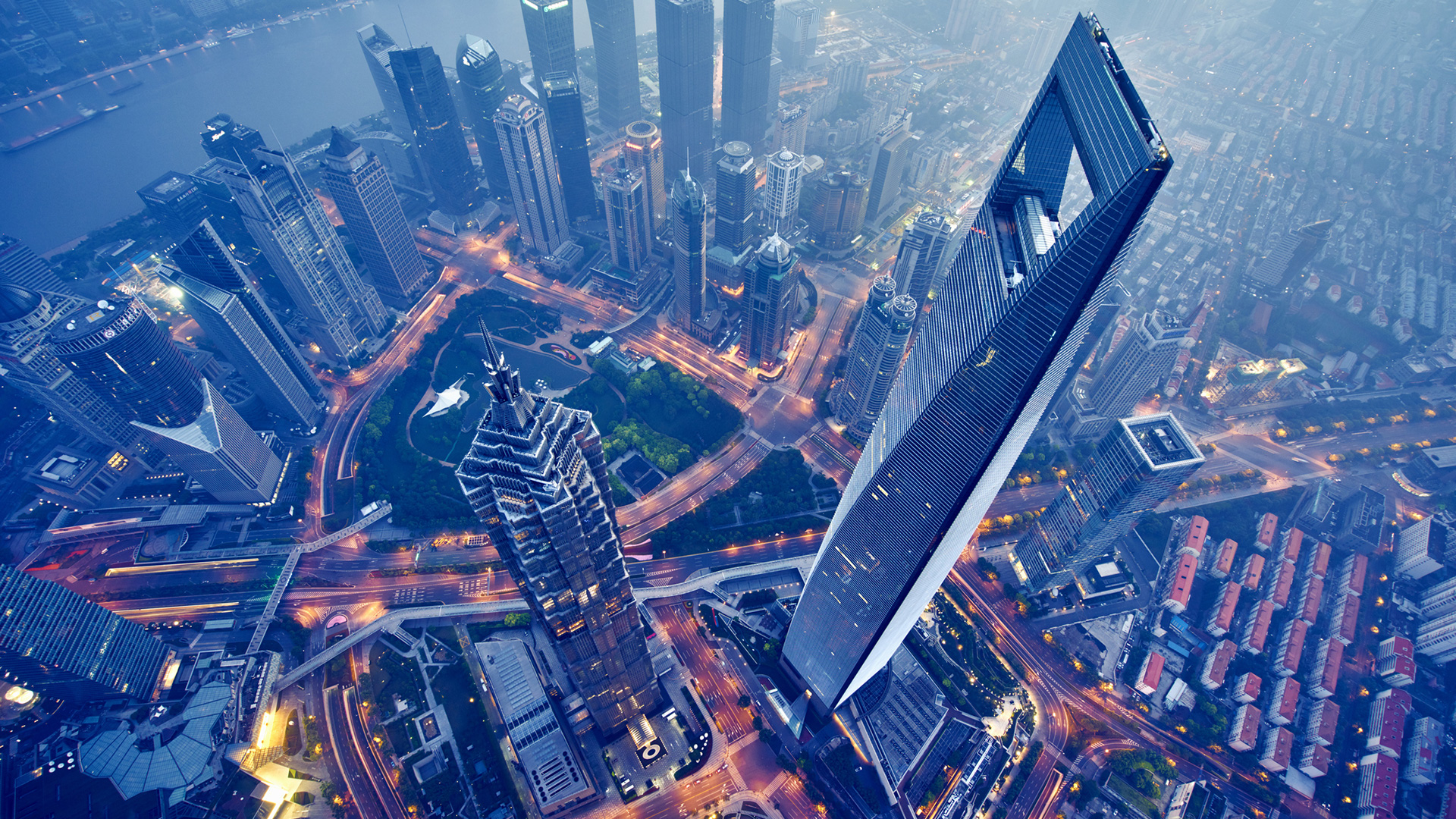 An aerial view of a city at night, illuminated by the glow of GSMA membership buildings.