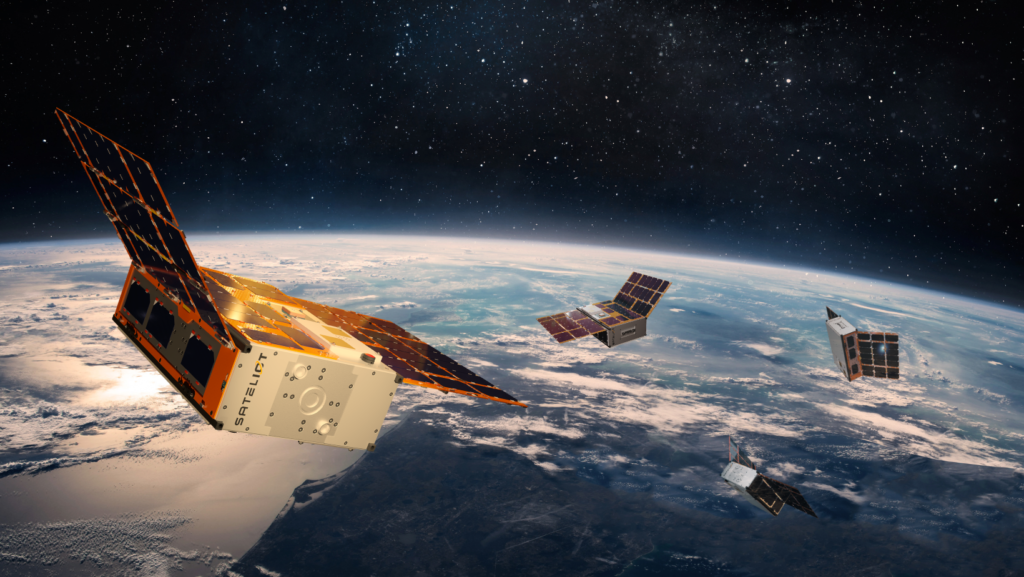 An illustration of several small cube-shaped satellites with solar panels floating in orbit above Earth. The satellites are against a backdrop of space, with part of the planet and its atmosphere visible below.