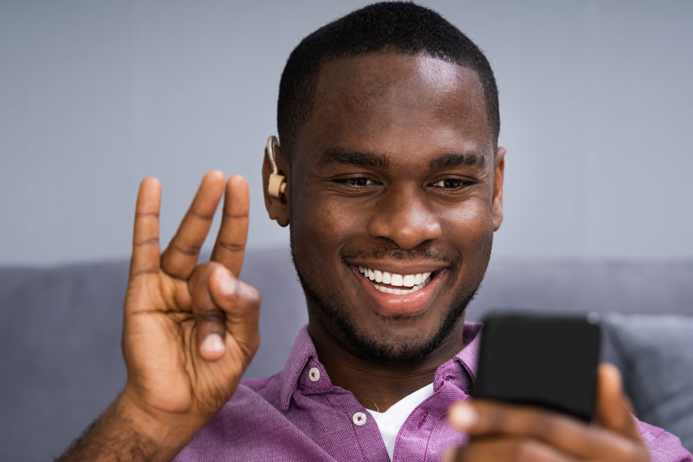 A deaf Black man using sign language on a video call