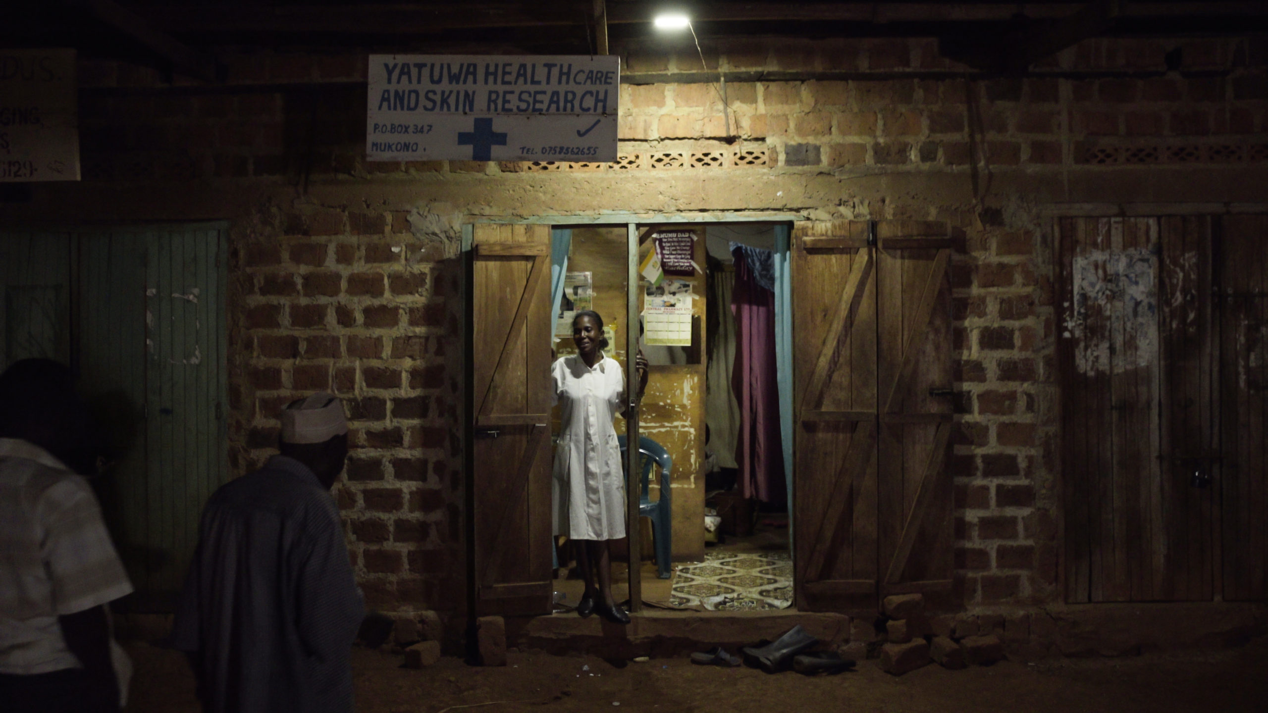 Woman in doorway of health clinic with single light
