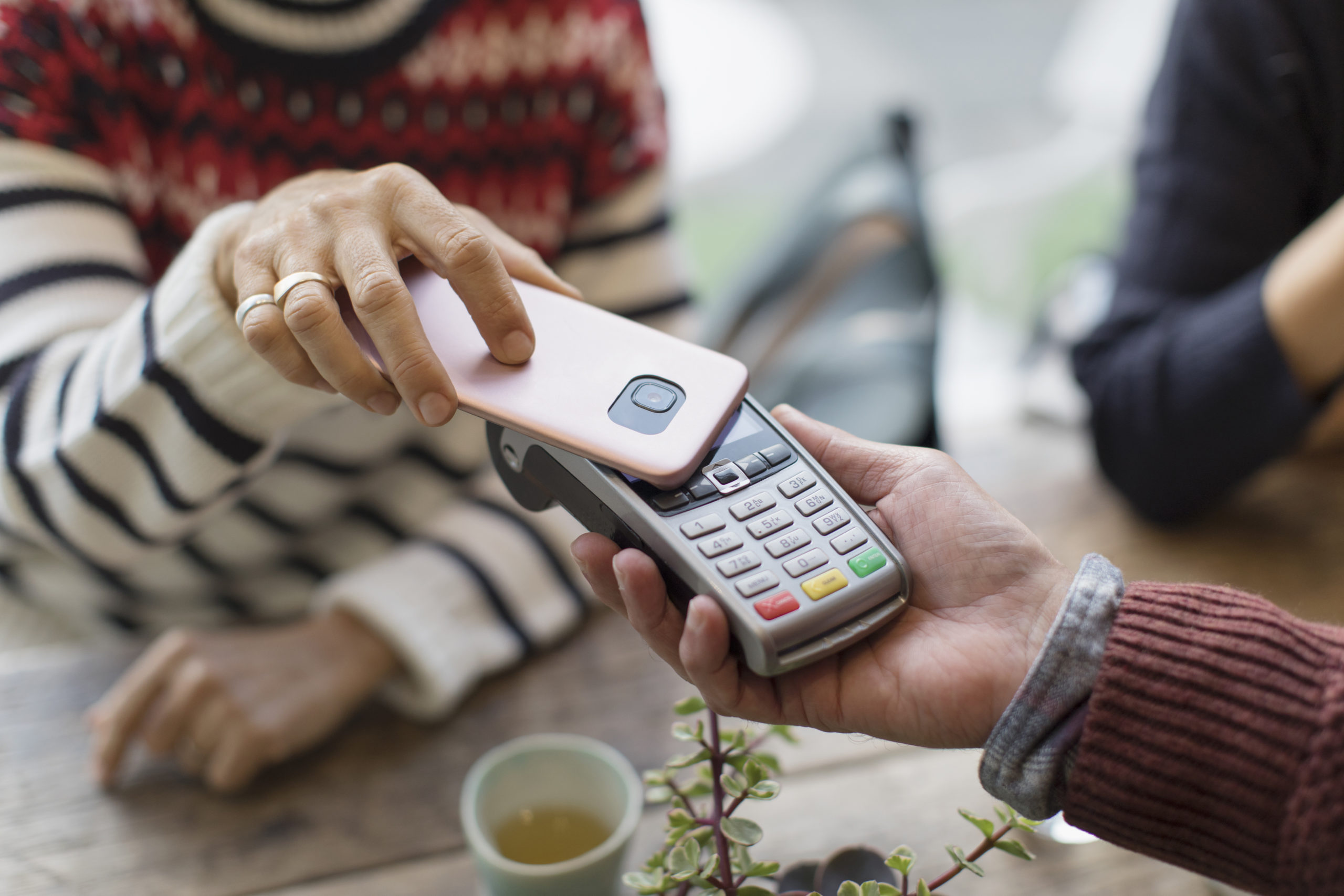 Woman with smart phone using contactless payment