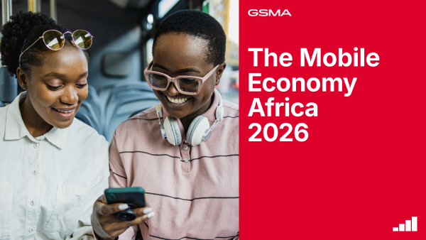 Two smiling women sit on a bus, looking at a smartphone together. One wears a striped shirt and large headphones, the other wears sunglasses on her head. Next to them, a red panel reads "The Mobile Economy Africa 2026" with the GSMA logo.