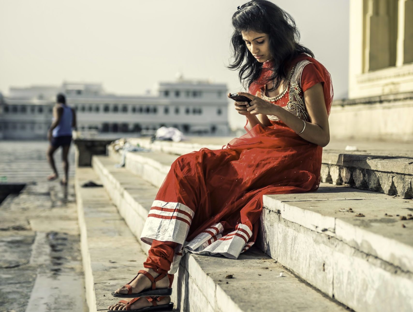 Young Indian woman sitting on Ambrai Ghat steps, Udaipur