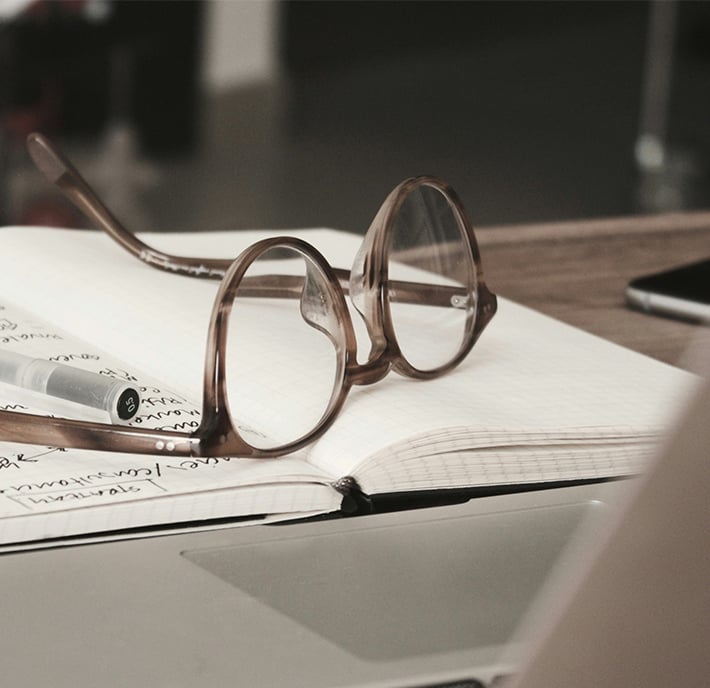 A pair of glasses rests on a notebook, ready for notes and ideas on climate action.