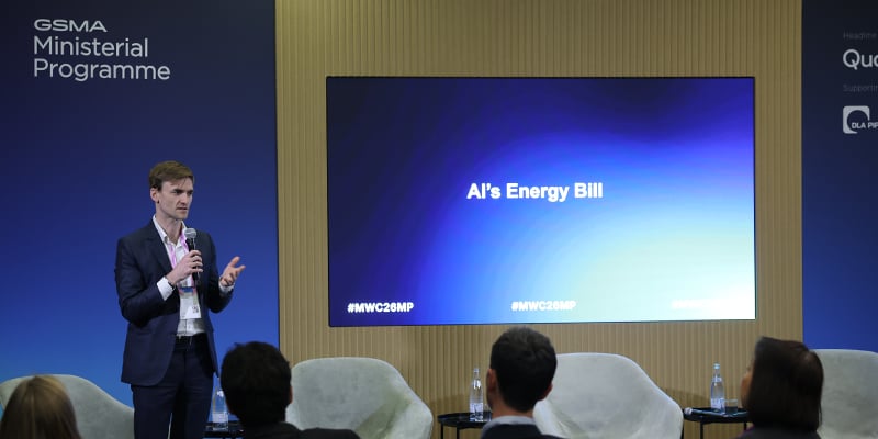 AI Energy Consumption Discussion for Policymakers and Regulators on stage at MWC Barcelona 2026, with a screen behind displaying the text "AI's Energy Bill.
