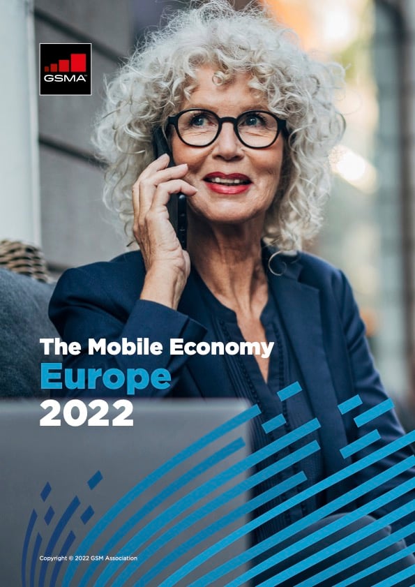 A smiling older woman with curly grey hair and glasses talks on a mobile phone outdoors. She wears a navy blazer. The cover features the GSMA logo and reads: "The Mobile Economy Europe 2022" over a blue abstract design.