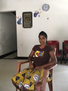 Anusha sits in a chair at her parents' home.