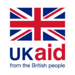 Logo featuring the Union Jack flag at the top. Below, in bold blue and red text, it reads "UK aid." Underneath, smaller blue text states "from the British people." The design conveys a message of assistance and cooperation from the United Kingdom.