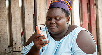 A woman using a smartphone with a focused expression.