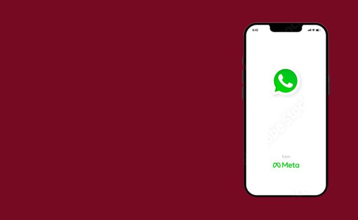 Smartphone with whatsapp application open on the screen against a maroon background.