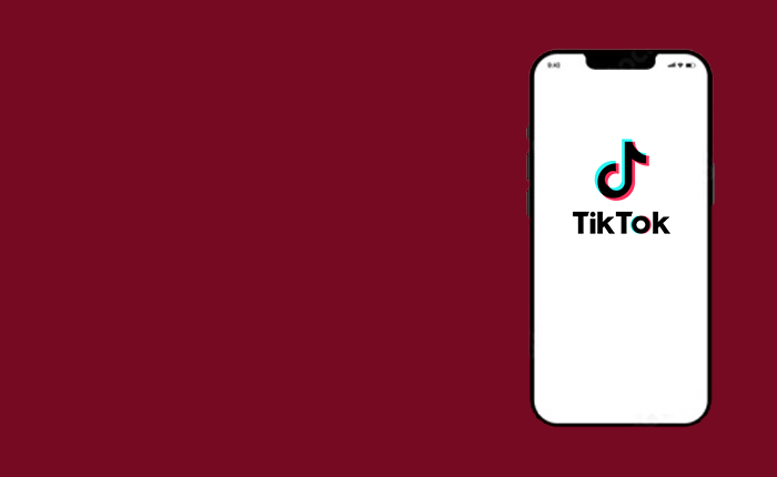 A smartphone with a white screen displays the TikTok logo, featuring a musical note and the text "TikTok" below it. The phone is positioned against a solid maroon background, slightly to the right side of the image.