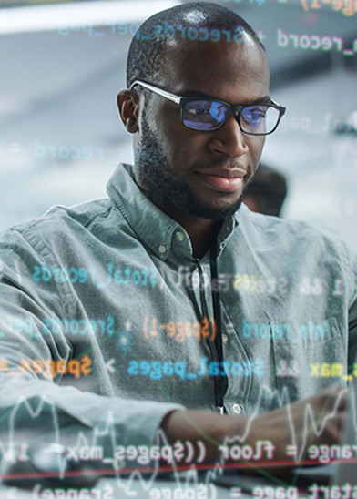 A man wearing glasses and a button-up shirt is looking at a computer screen. There are blurred lines of code and data graphics overlaid on the image.