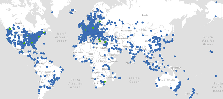 A world map displays numerous blue dots scattered across various countries, indicating specific locations. Clusters are visible in North America, Europe, and Asia. Smaller concentrations compute in South America, Africa, and Australia. A few green dots are also scattered among the blue ones.