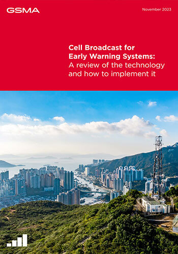 A cityscape with tall buildings, mountains, and water under a blue sky. In the foreground, a cell tower stands on a green hillside. The top third features a red banner highlighting Tanzania's mobile-enabled early warning systems for safety alerts.
