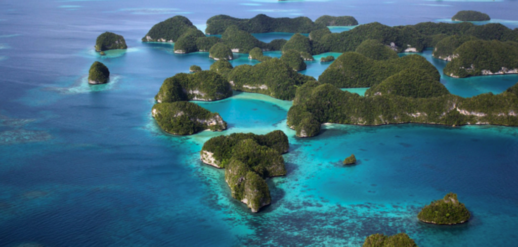 Aerial view of lush, green islands surrounded by clear blue sea and shallow turquoise waters, ideal for monitoring early warning systems.
