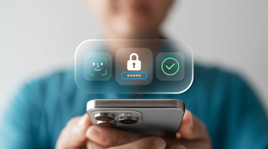A person holds a mobile phone close to the camera. Floating icons show Face ID, a lock with a password field, and a green tick, representing security or authentication. The person’s face is blurred and the background is neutral.