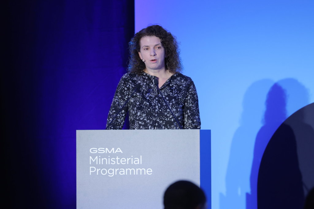 Woman presenting at a podium labeled "GSMA Ministerial Programme 2024" in a conference room.