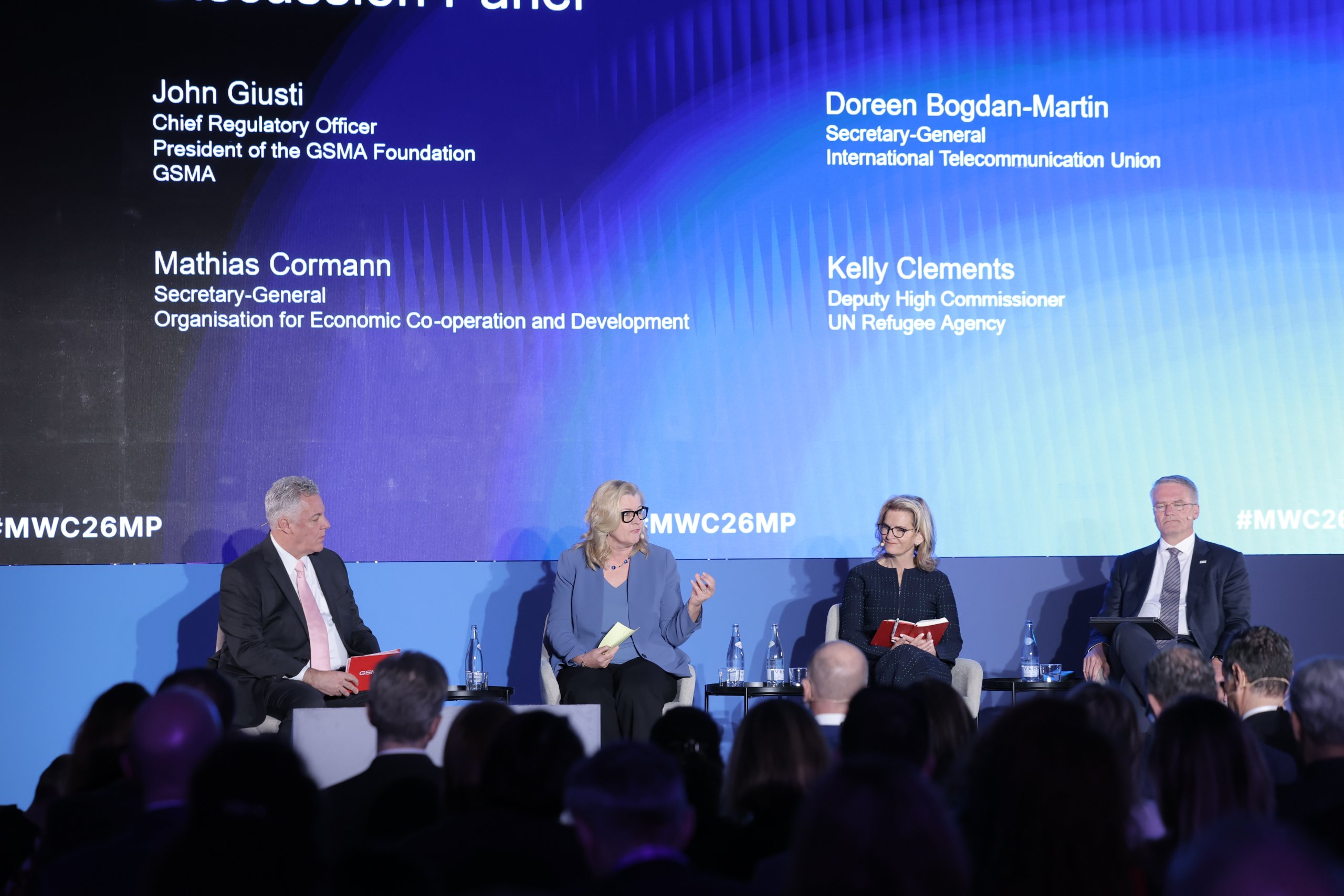 Four panelists in professional attire sit on stage discussing key Ministerial Programme 2026 takeaways at a conference, with the audience visible in the foreground.