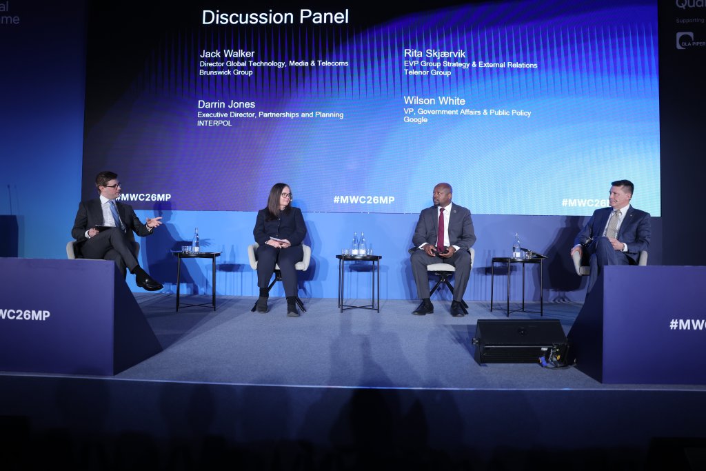 Four panelists sit on stage discussing technology topics at the MWC26MP conference, blue lighting behind them.