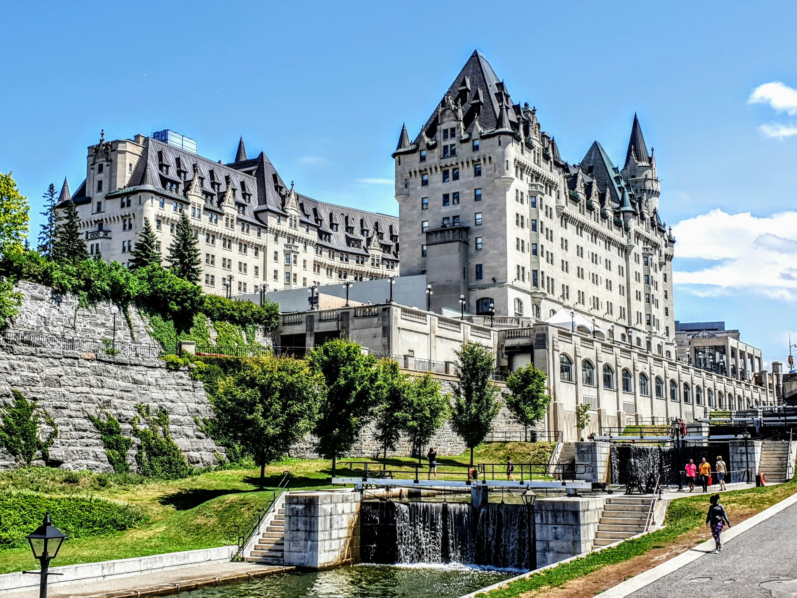 Large historic hotel with pointed towers beside a canal and park under a bright blue sky, once a gathering place for mobile industry public policy discussions.