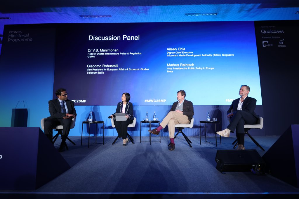 Four panelists sit on stage discussing policy at a conference, with a large screen displaying their names and key Ministerial Programme 2026 takeaways behind them.