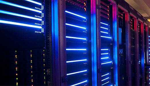 Close-up of illuminated server racks with blue and purple lights in a data center.