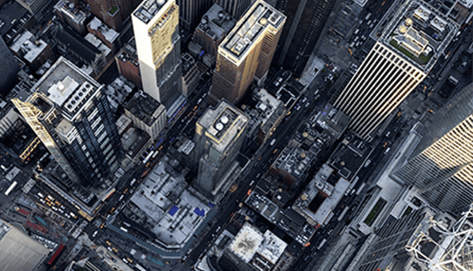 Aerial view of city skyscrapers and busy streets intersecting below.