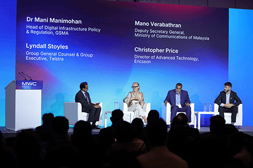 Four panelists sit on stage at the Policy Leaders Forum Shanghai at MWC, participating in a discussion. Behind them, a large blue and purple screen displays their names and titles. An attentive audience watches in the foreground.