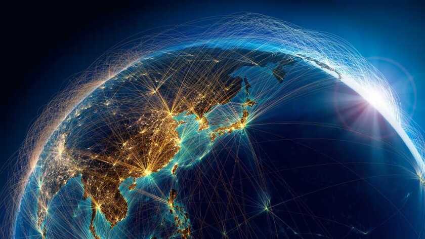 A view of Earth from space at night, showing Asia with bright city lights. Thin, illuminated lines connect various points, representing global digital connections. The sun peeks over the horizon, casting a blue glow. The image conveys a sense of worldwide communication and technology.