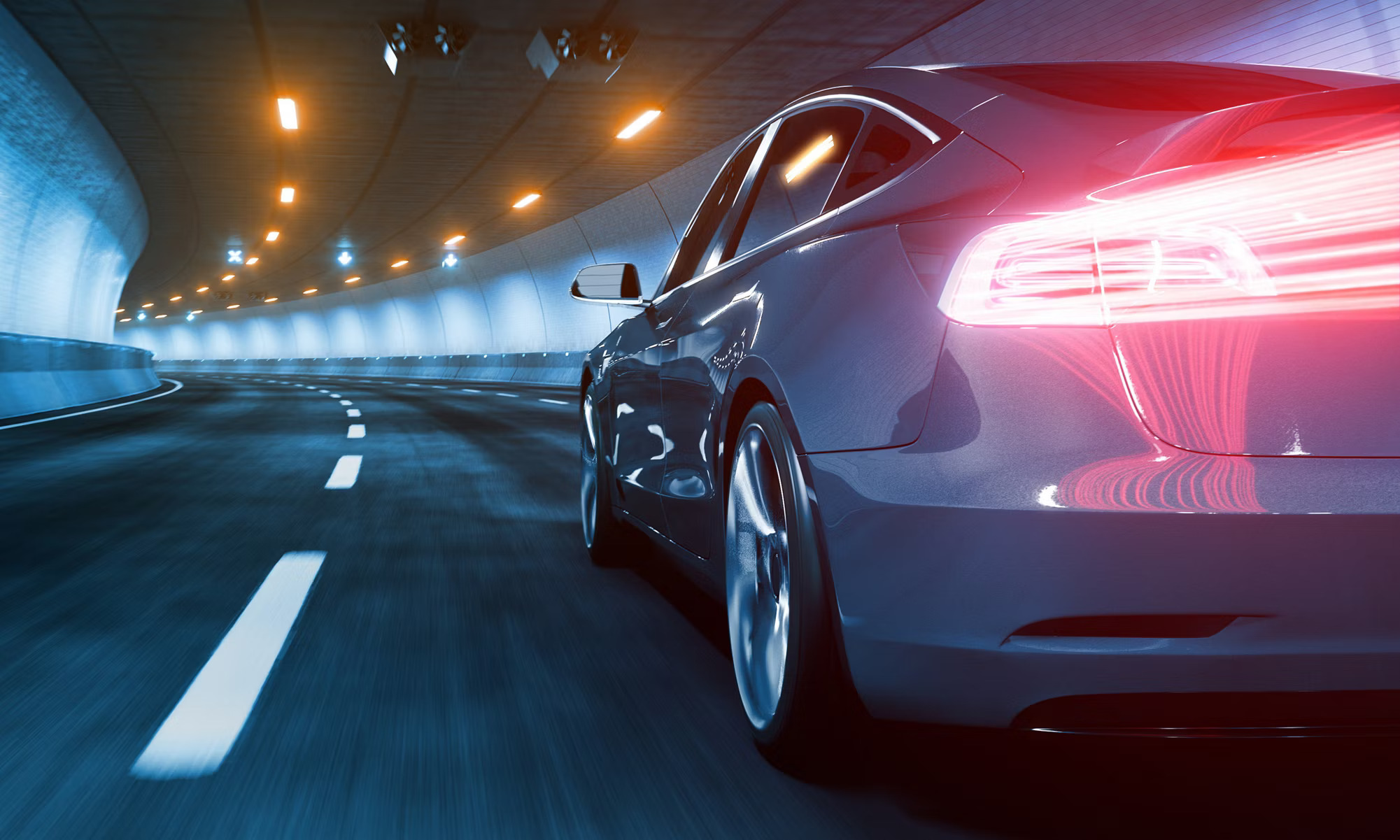 A sleek, modern car with illuminated taillights speeds through a well-lit tunnel. The polished, dark exterior reflects the tunnel lights, and the road features clear lane markings. The scene conveys motion and futuristic design elements.