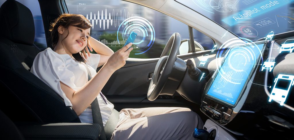 A woman relaxes in the driver’s seat of a modern car, holding her phone as futuristic graphics show autopilot mode powered by open-gateway network APIs, highlighting how 5G network API technology drives seamless self-driving experiences.