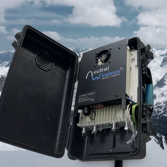 A wireless communication device in a black box, open on a snowy mountain landscape with cloudy skies.