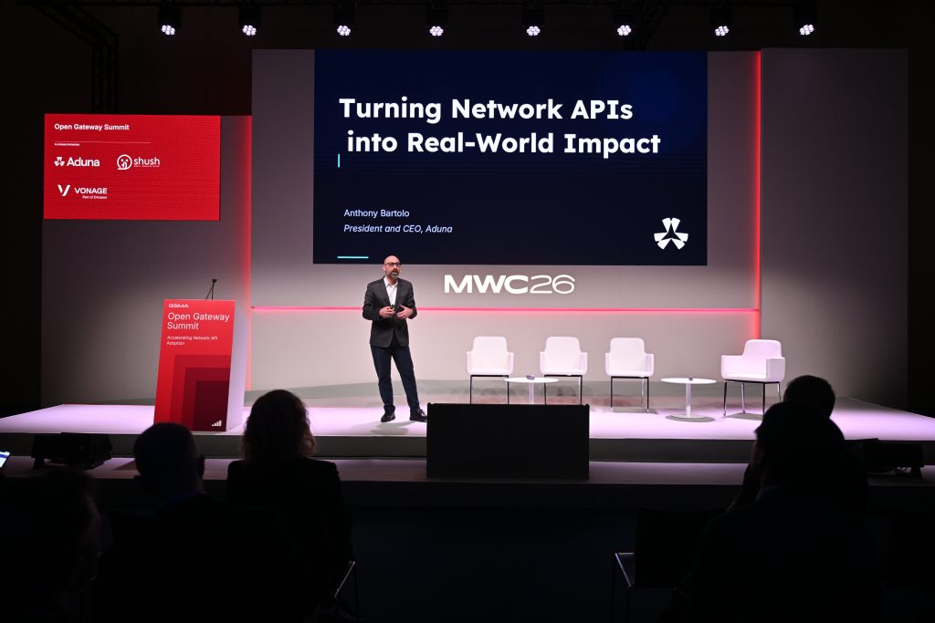 A speaker presents "Turning Network APIs into Real-World Impact" at the MWC26 Open Gateway Summit, exploring api network monetisation and 5G operationalisation.