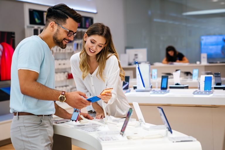 Two people looking at phones in a retail setting