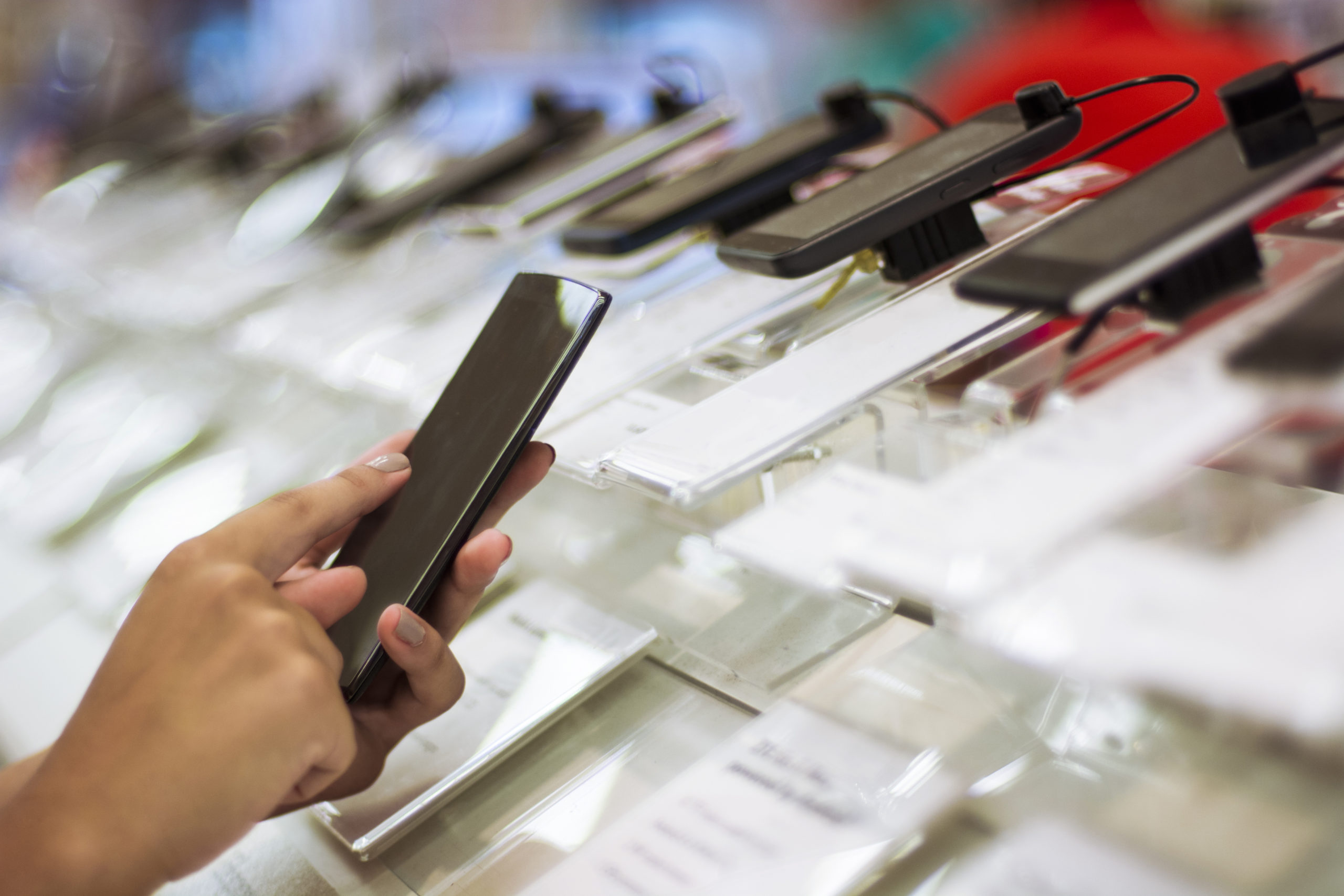 Person checking a used phone to purchase at a shop