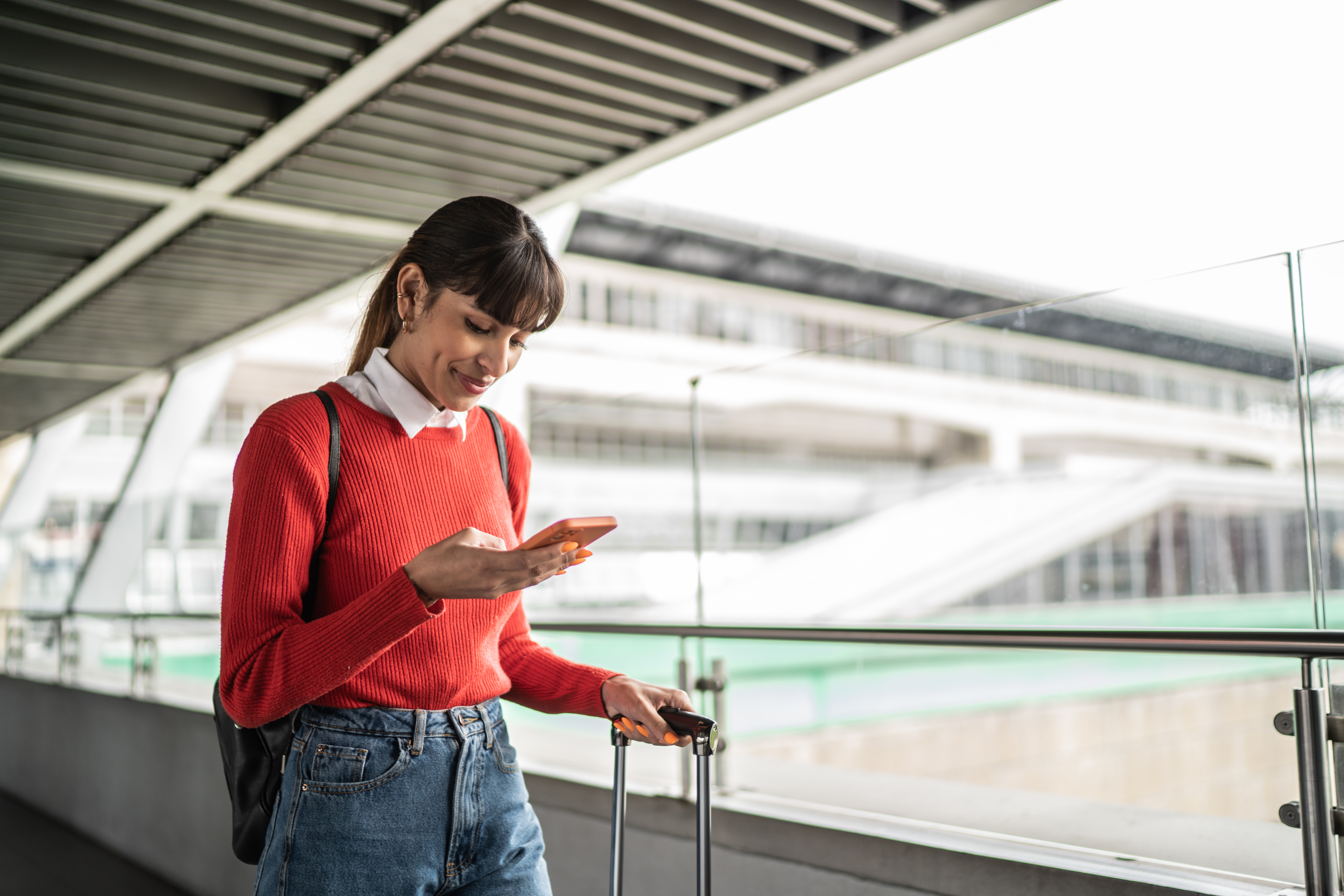 Traveler young woman using the mobile phone in a subway station