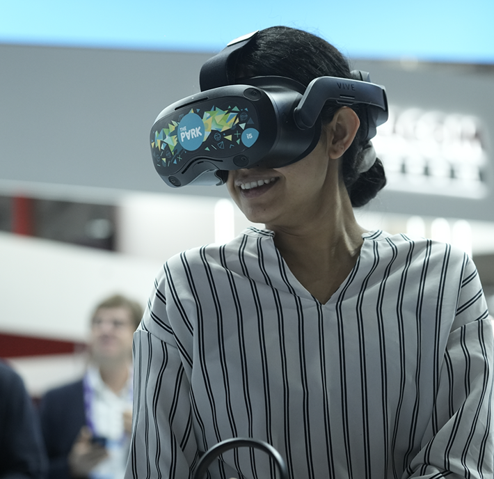 A woman wearing a vr headset at a trade show.