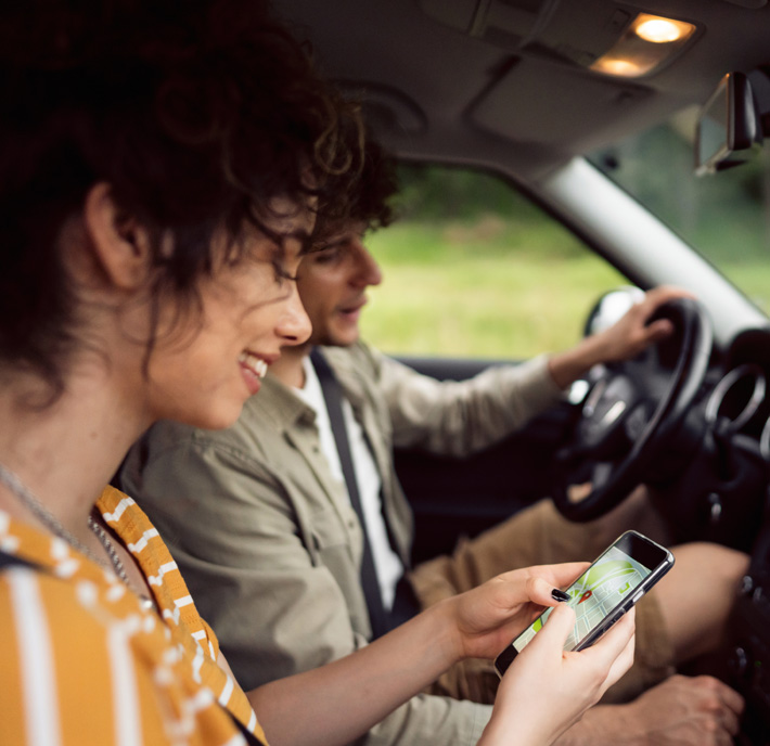 Woman and man in car and woman holding mobile phone